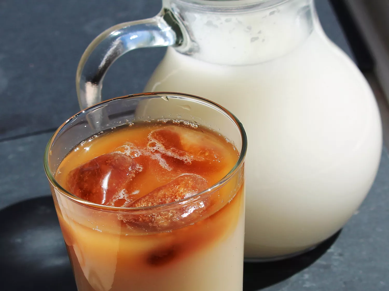 Close up view of horchata with coffee in a glass and horchata in a pitcher