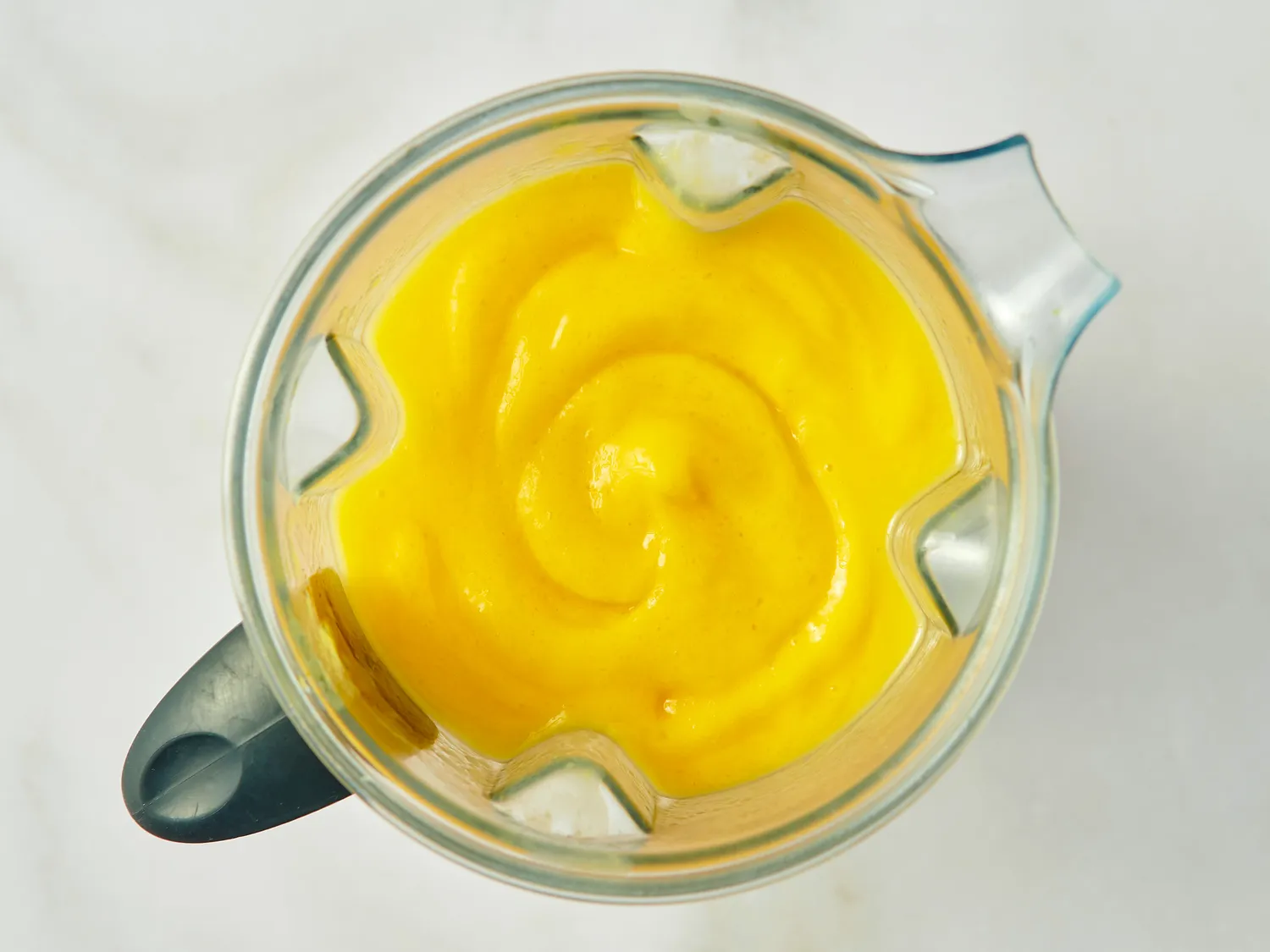 Blender with mango lassi mixture in view from overhead