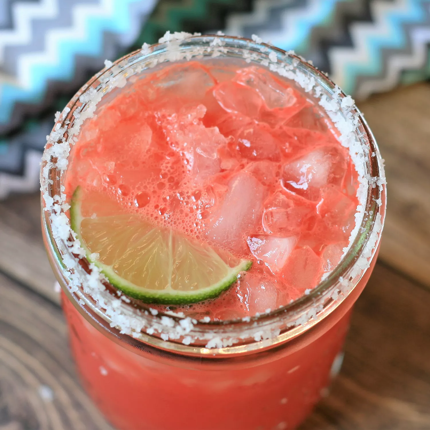 close up view of a Watermelon Margaritas garnished with a lime wedge and salt on the rim of the glass