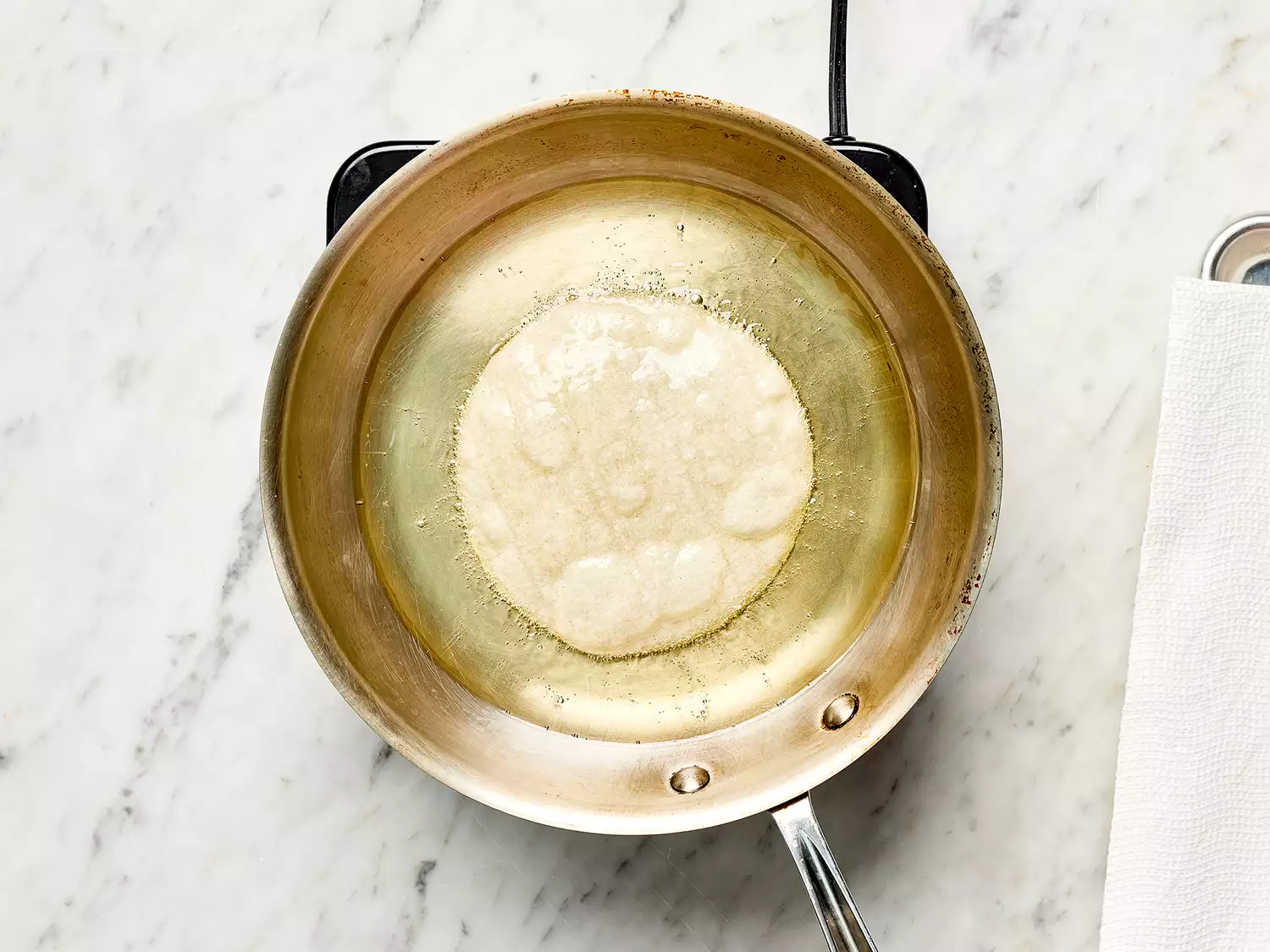 Corn tortilla with oil in a pan on a burner 