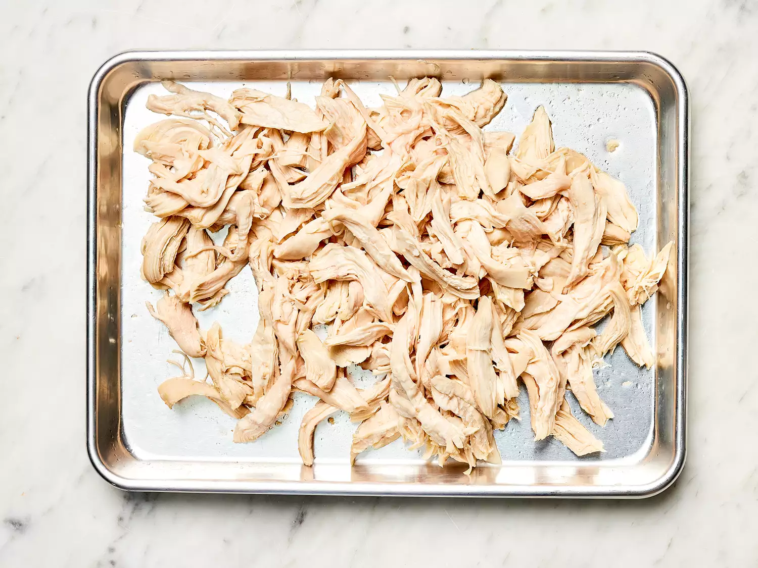 Shredded chicken on a baking sheet 