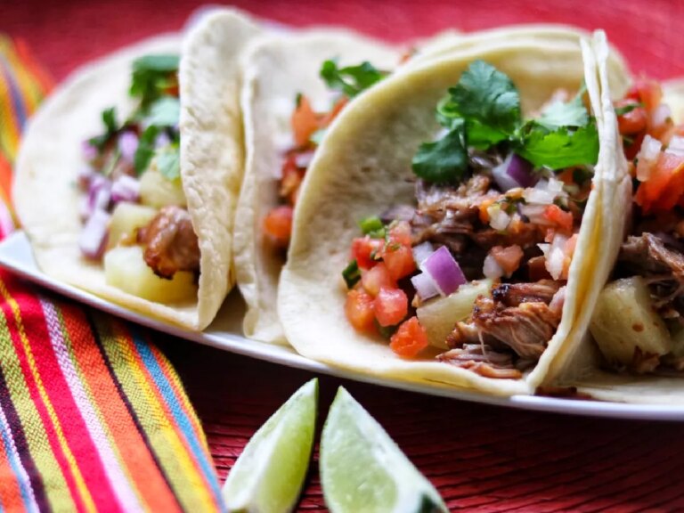 Close up view of instant pot tacos al pastor garnished with fresh herbs on a platter