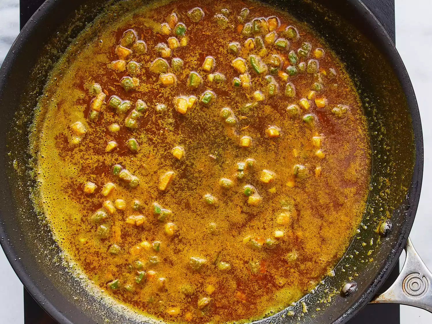Turmeric, chile pepper, and garlic in large skillet
