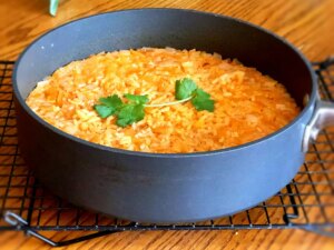 Close up view of mexican rice garnished with fresh herbs in a pan