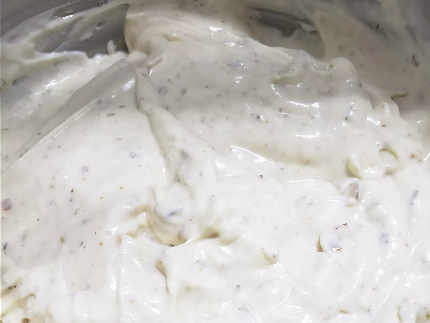 Close up view of mexican white sauce in a metal bowl