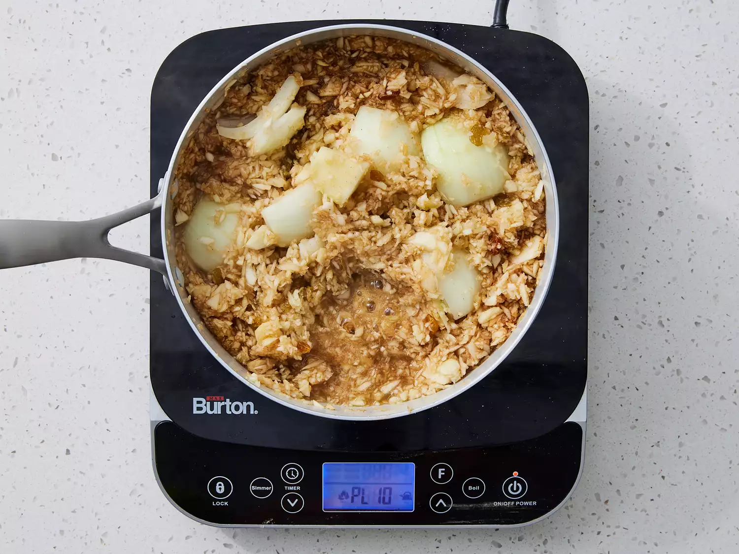 apples, onion, ginger, vinegar, white sugar, brown sugar, cinnamon, white pepper, cardamom, and nutmeg in a large saucepan coming to a boil.