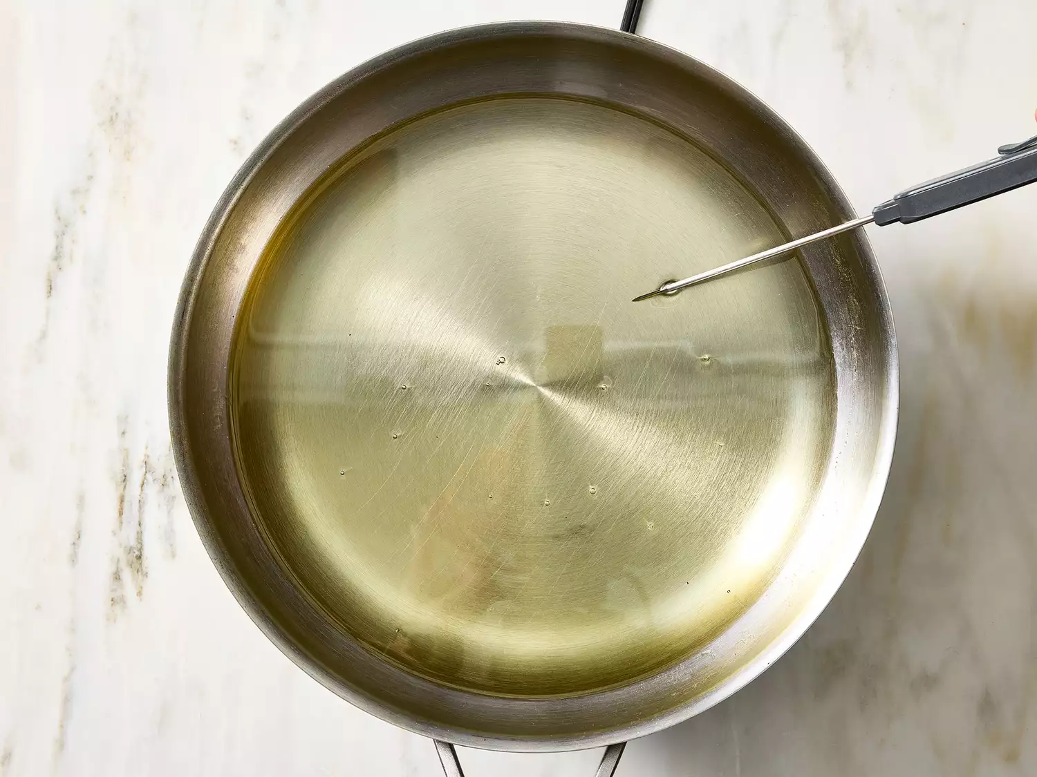 Pan with heated oil prepared for frying taco shells.