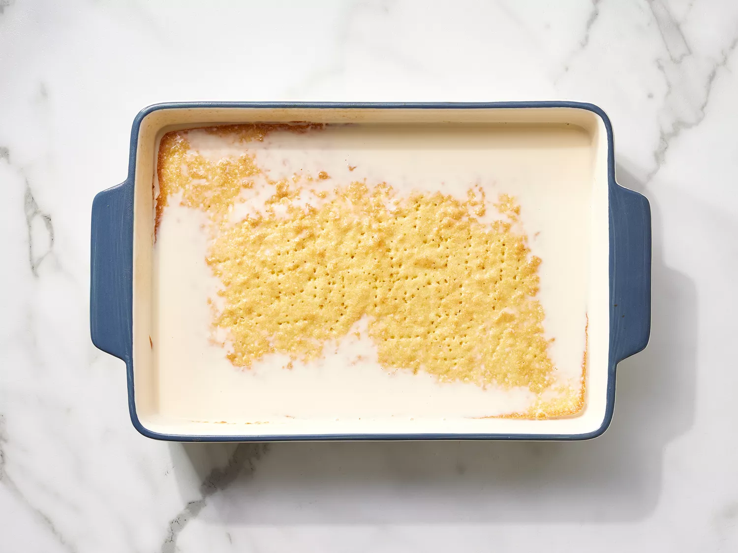 Cake with soaked with milk mixture in a baking dish 