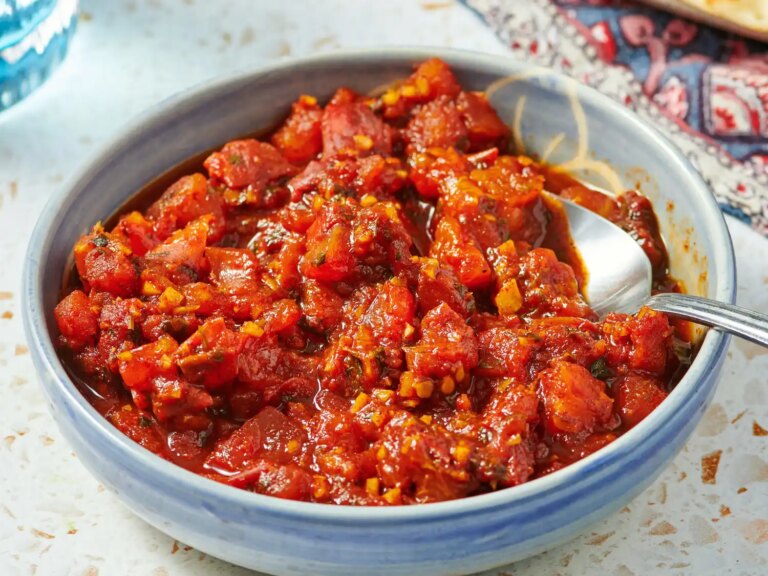 Tomato chutney served in a bowl with a spoon