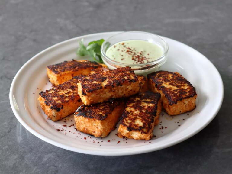 Homemade paneer with spices and dip on white plate