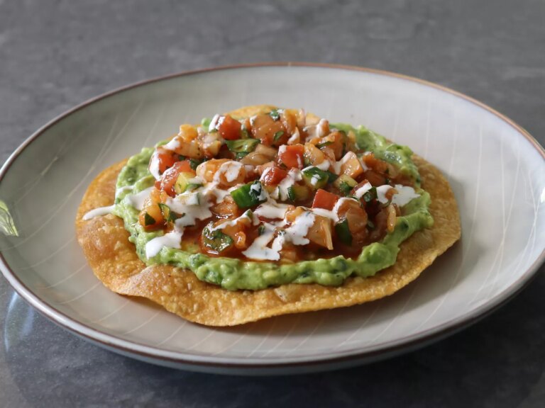 Deviled shrimp tostada with guacamole on plate
