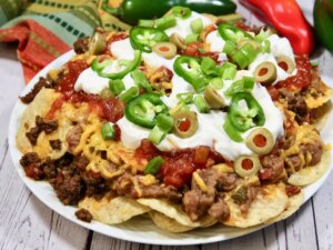 Loaded beef nachos topped with sour cream, jalapenos and olives