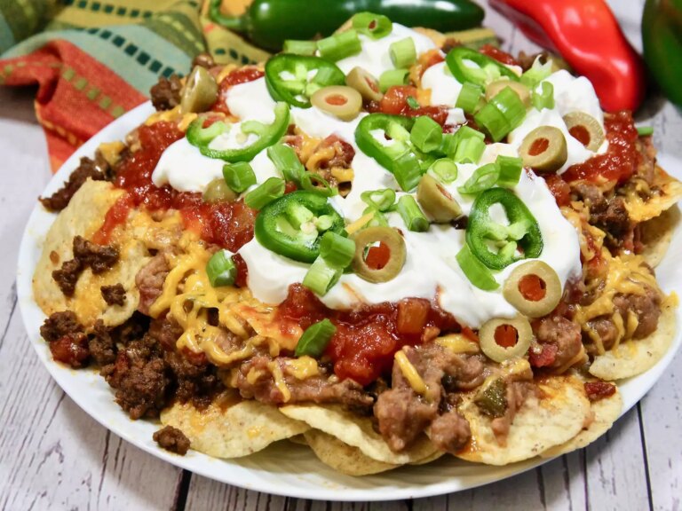 Loaded beef nachos topped with sour cream, jalapenos and olives