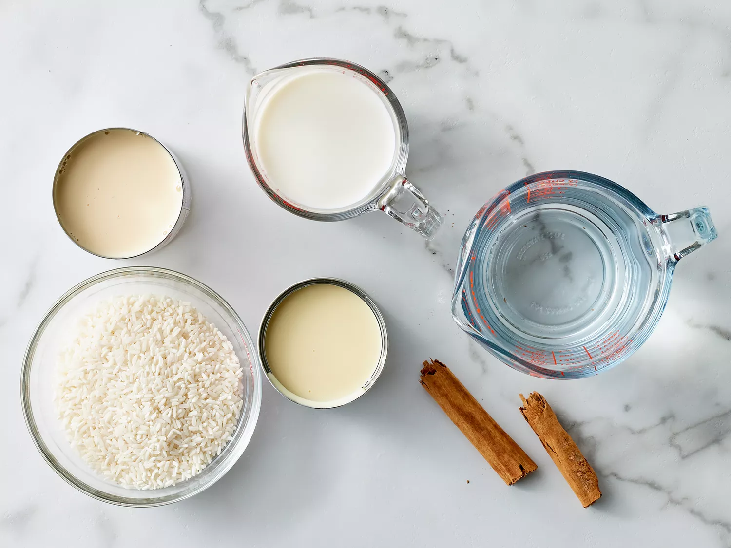 all ingredients to make arroz con leche gathered on a marble countertop. 