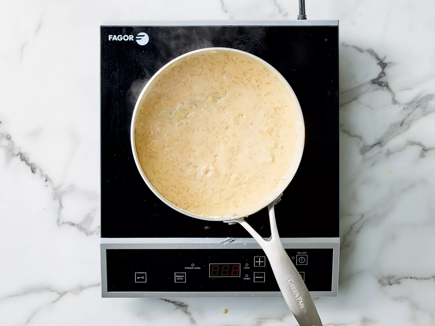condensed milk added to steamed rice in medium sauce pan. 