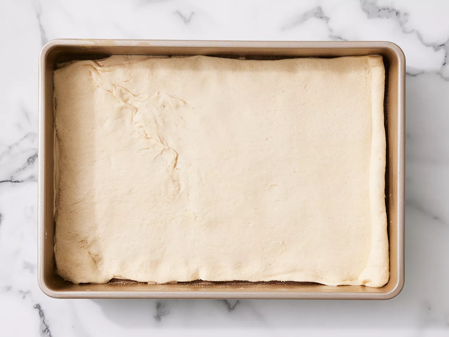 crescent sheet placed on top of cream cheese in baking pan. 