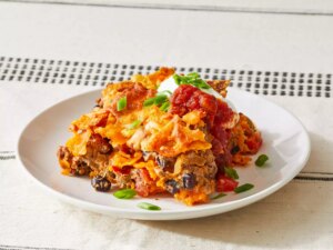 A single serving of dorito casserole on a small white plate.