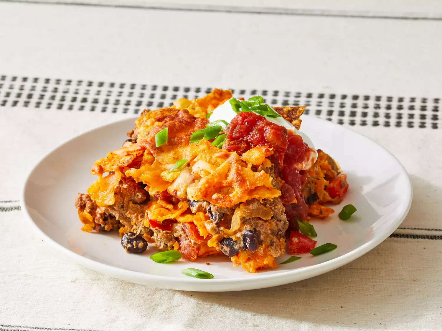 A single serving of dorito casserole on a small white plate.