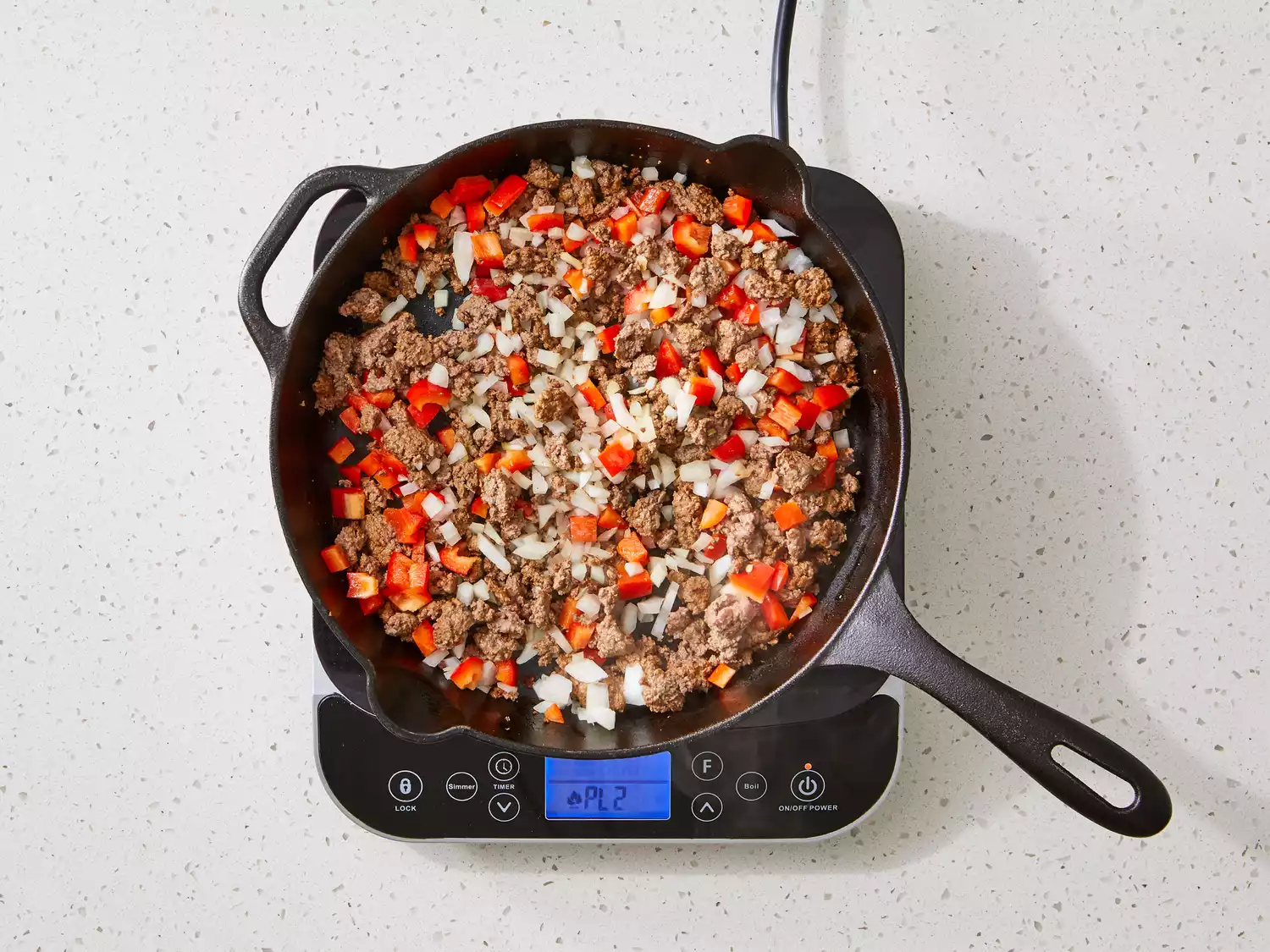 peppers and onion added to cast iron with ground beef.