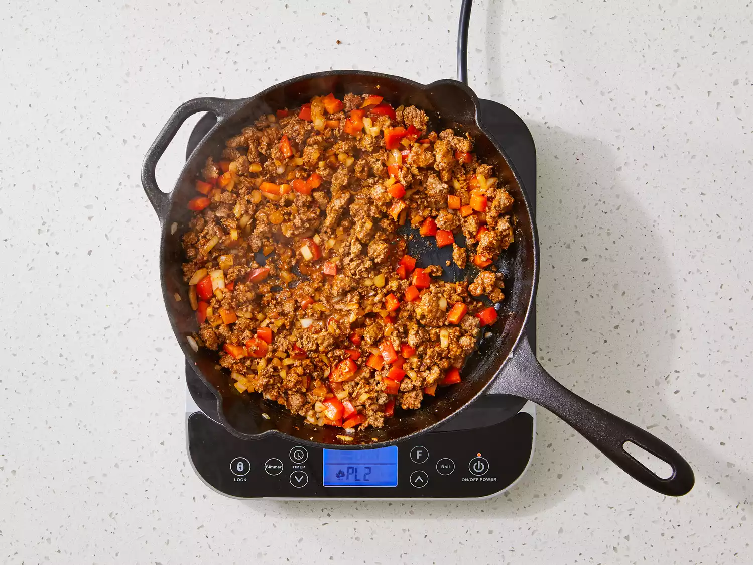 seasoned ground beef, peppers and onions in a cast iron skillet. 