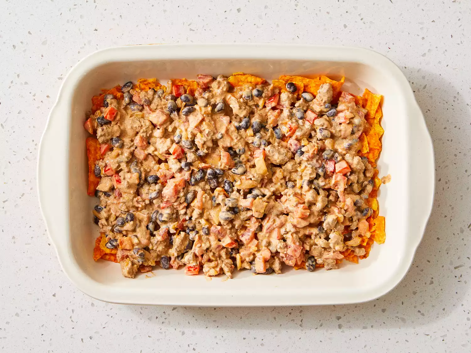 Layer of Dorito chips topped with creamy beef and veggie mixture.