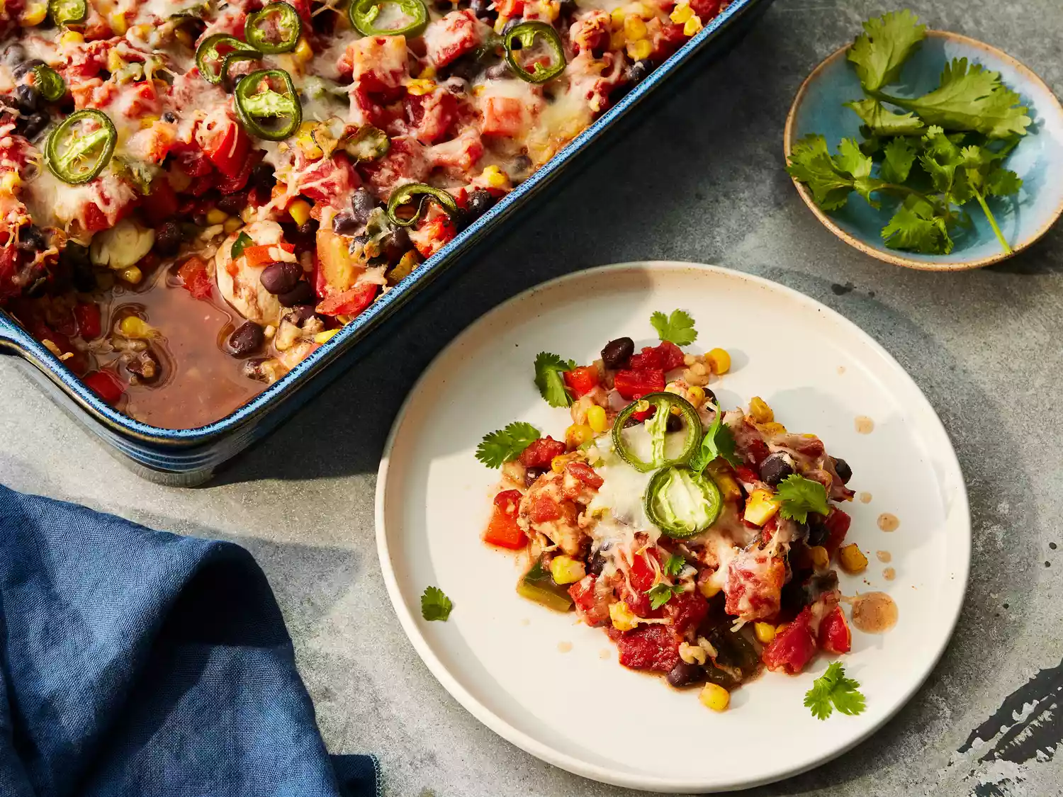 Looking down at a serving of dash diet mexican bake, with remaining in the casserole dish.