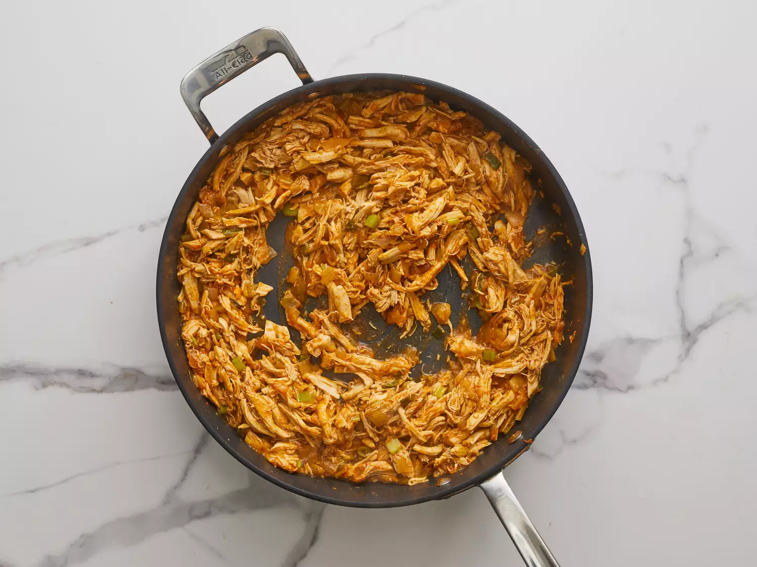 an overhead shot of shredded chicken mixture in a skillet