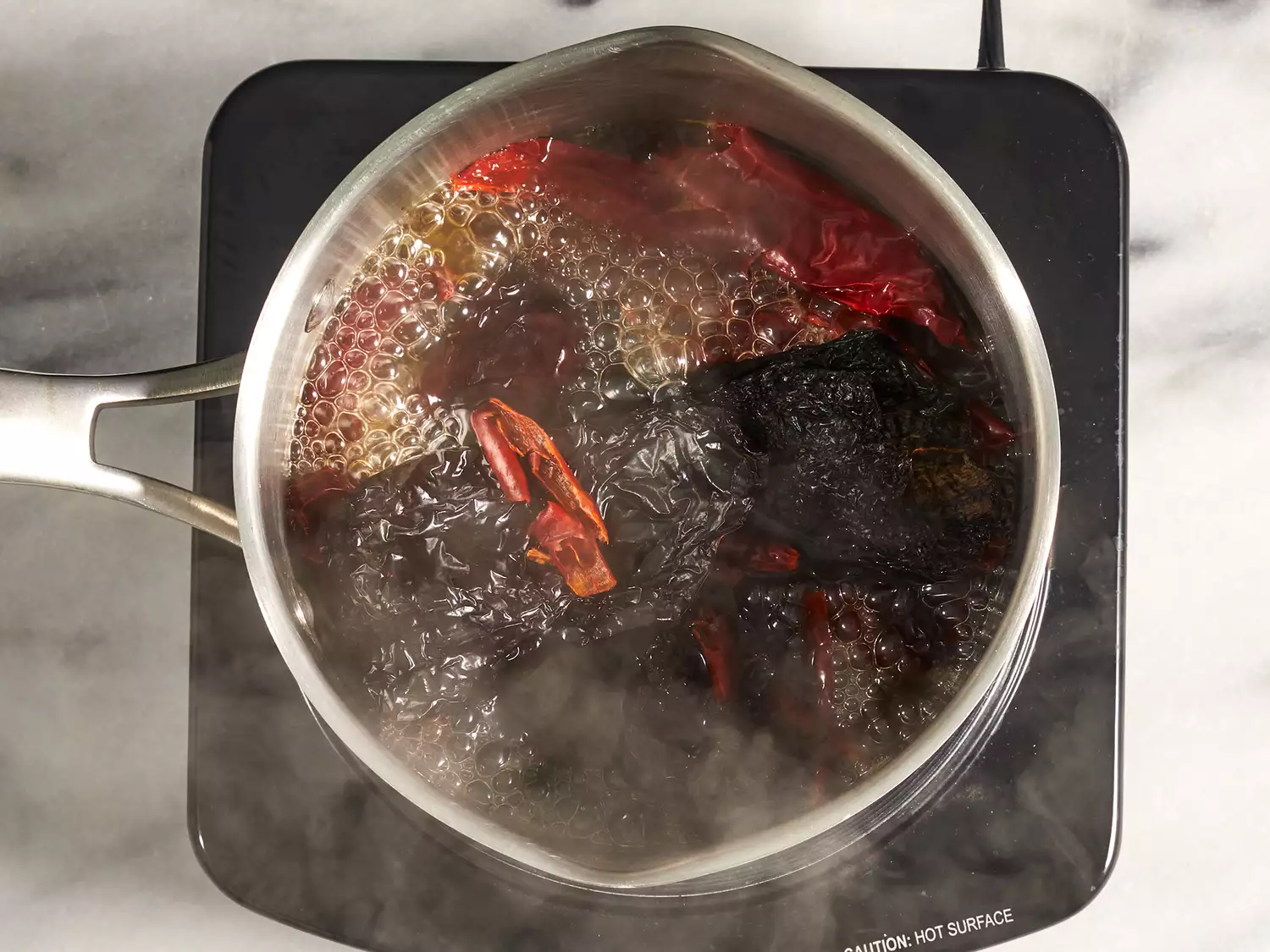 Chicken broth that has been boiled in a sauce pan with dried chiles added to it once off heat.