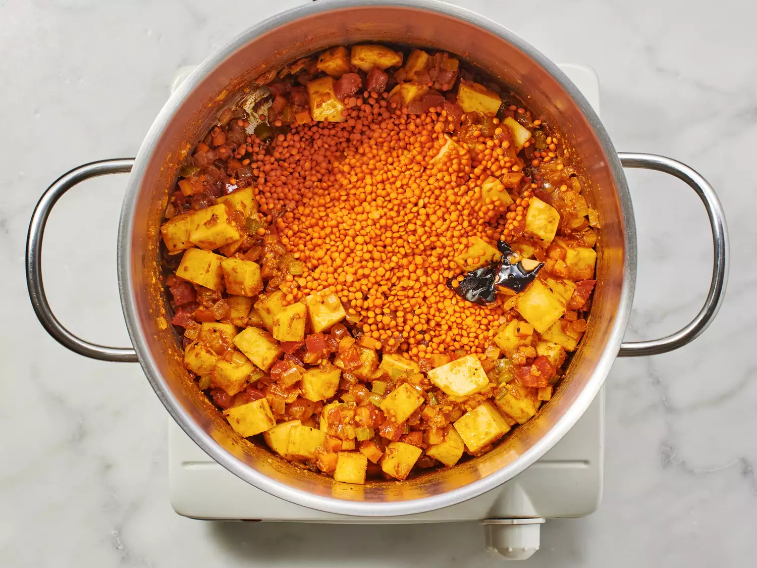 Potatoes and lentils in a stock pot. 