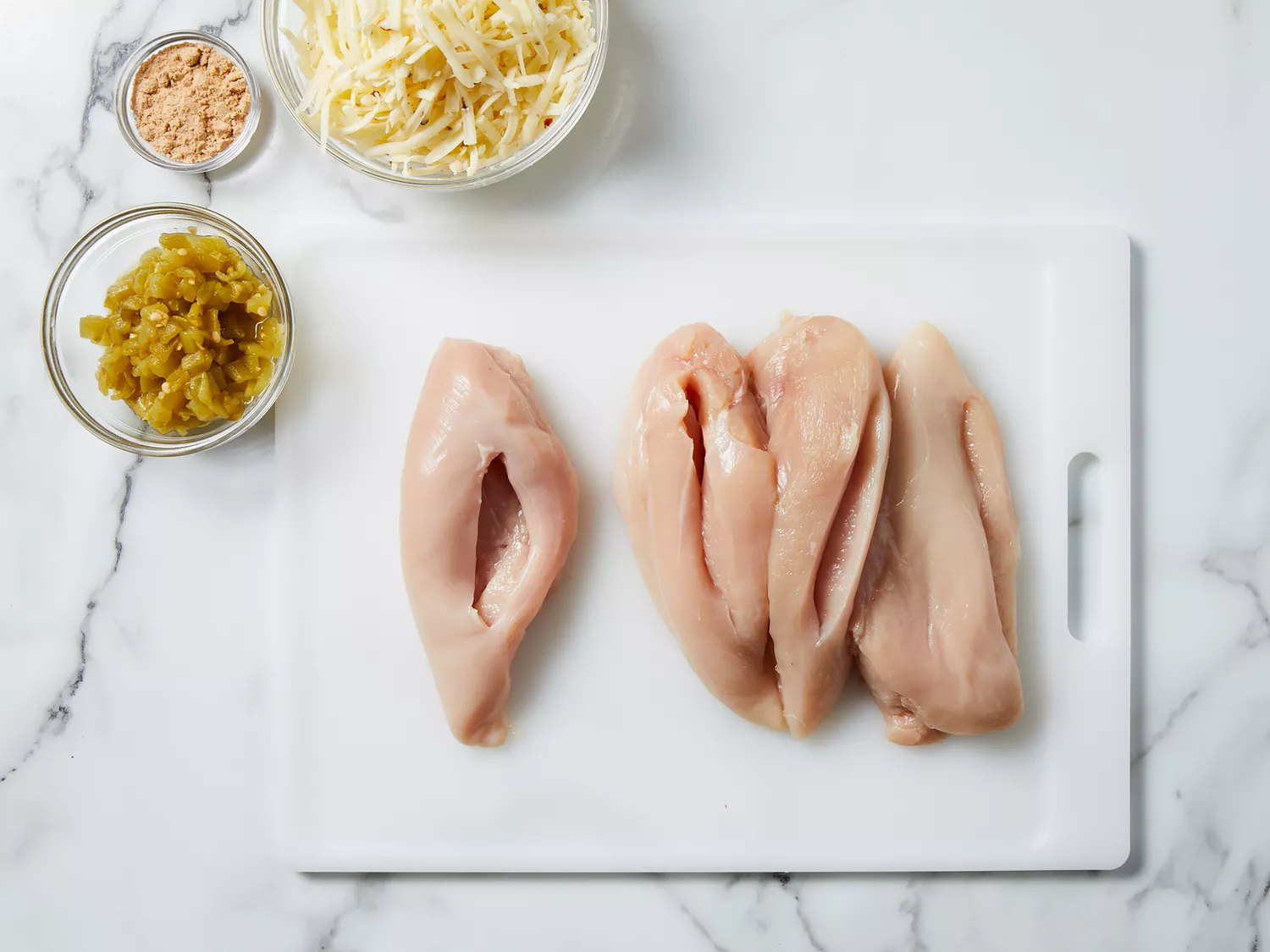 Deep cuts made into chicken breasts. 