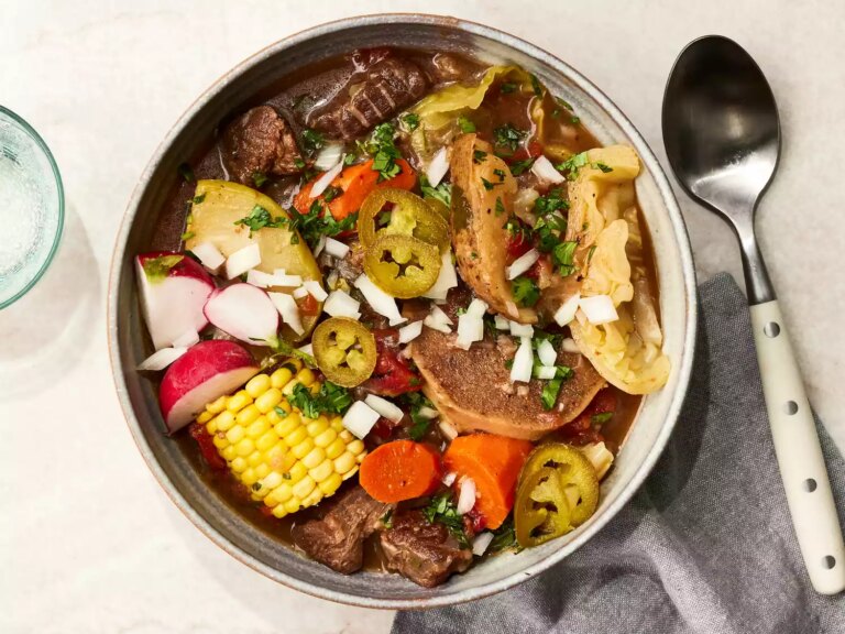 Caldo de res garnished and served in a bowl