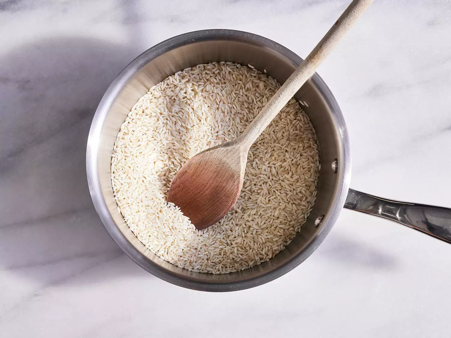 Uncooked rice added to sauce pan, cooking until fragrant. 