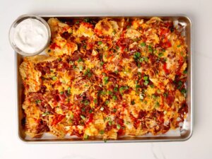 Overhead view of sheet pan with potato chip nachos and dipping sauce
