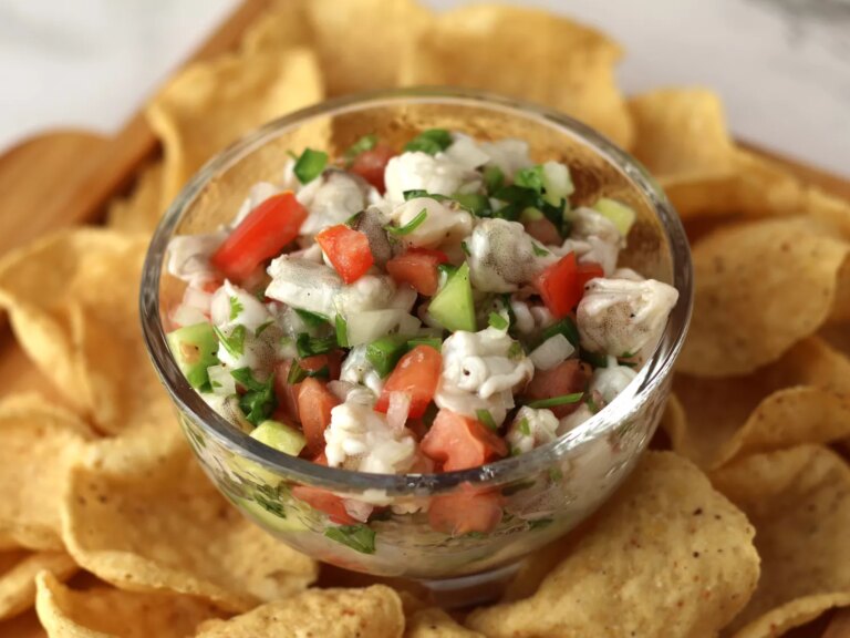 Close up ceviche in glass bowl surrounded by tortilla chips