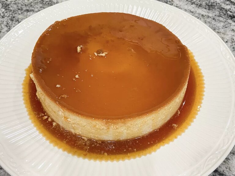 Close up view of a flan de coco (coconut flan) on a white platter