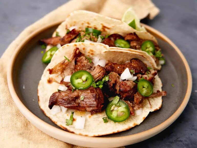 Open faced carnitas with sliced jalapenos and onions in tortilla