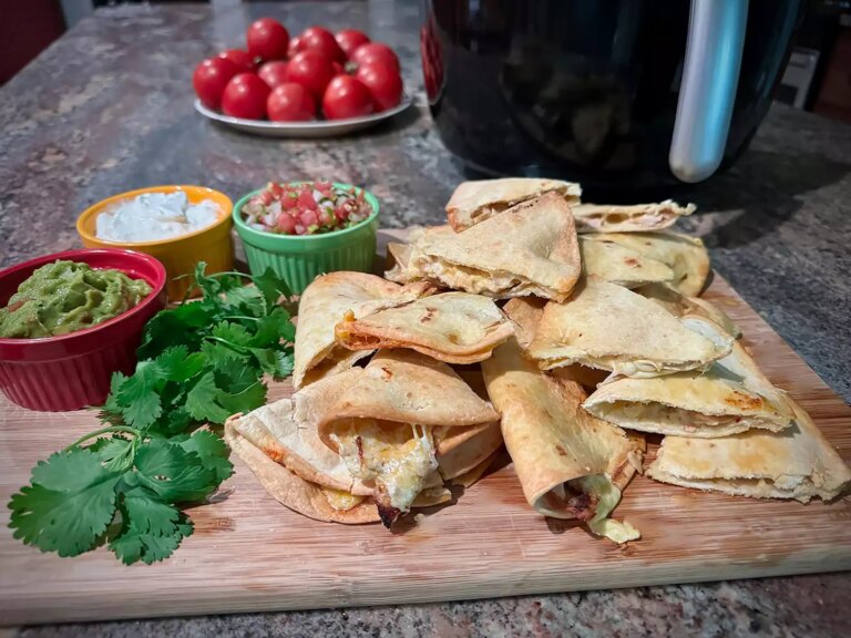 Stack of quesadillas on board with toppings arrayed beside them