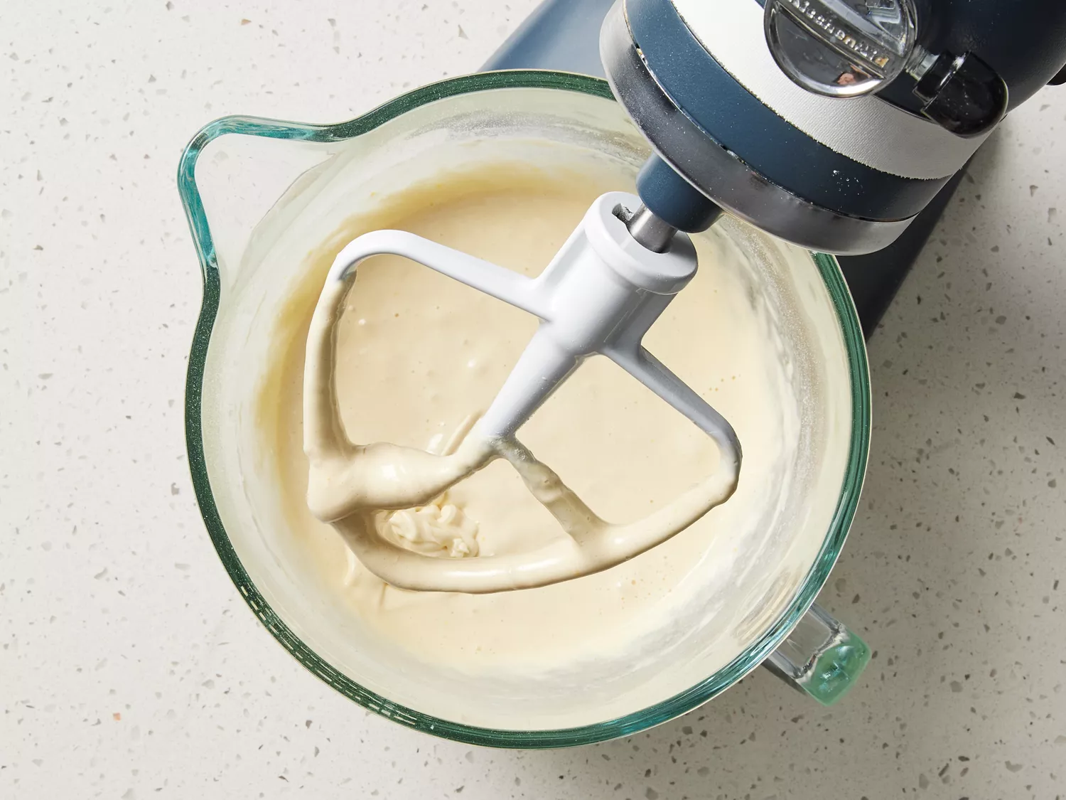 Batter in the glass bowl of a stand mixer 