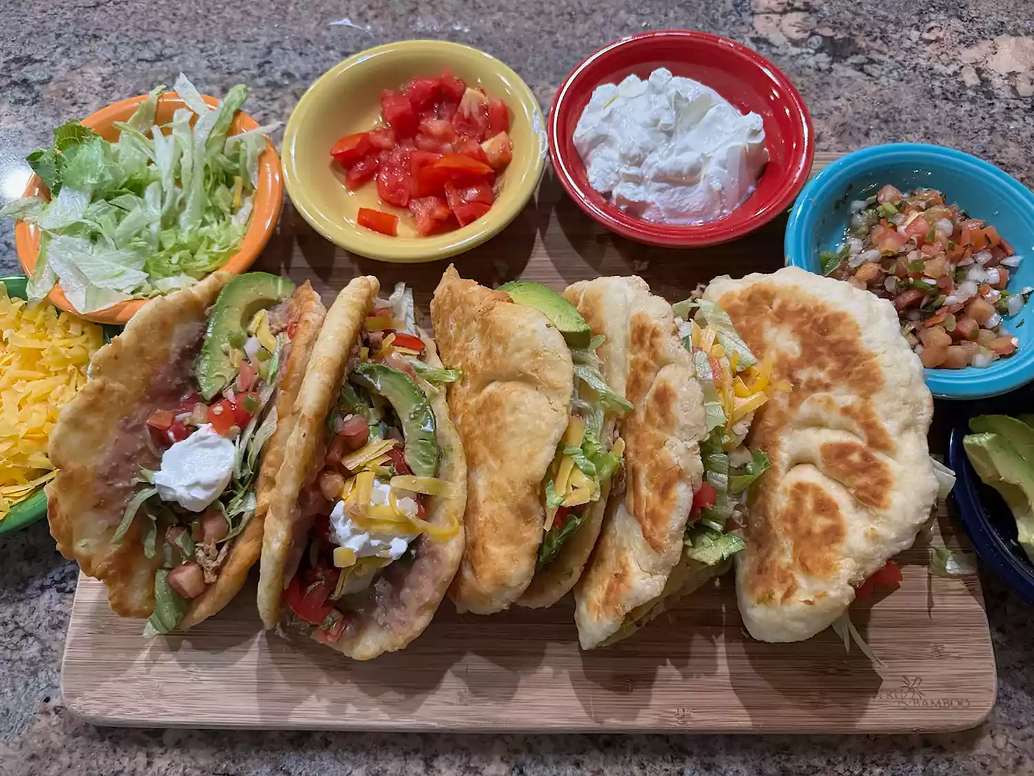 Board with 6 chicken filled chalupa shells and an array of toppings