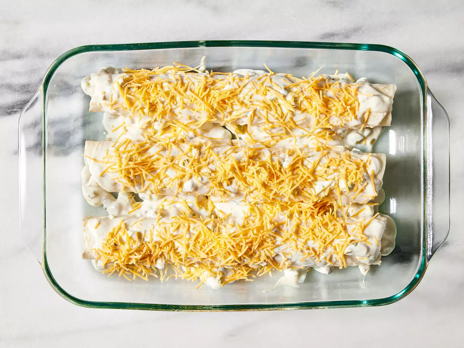 Mixture spooned over tortillas in prepared dish, then topped with remaining cheese.