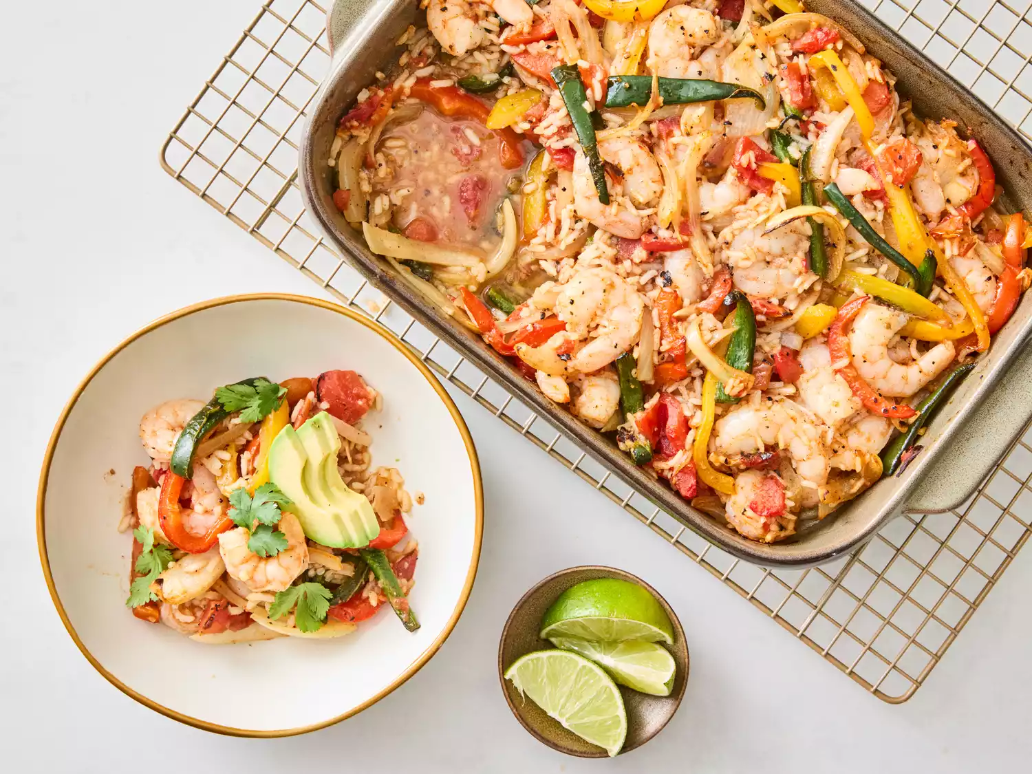 Casserole served in a bowl with avocado and lime on the side 