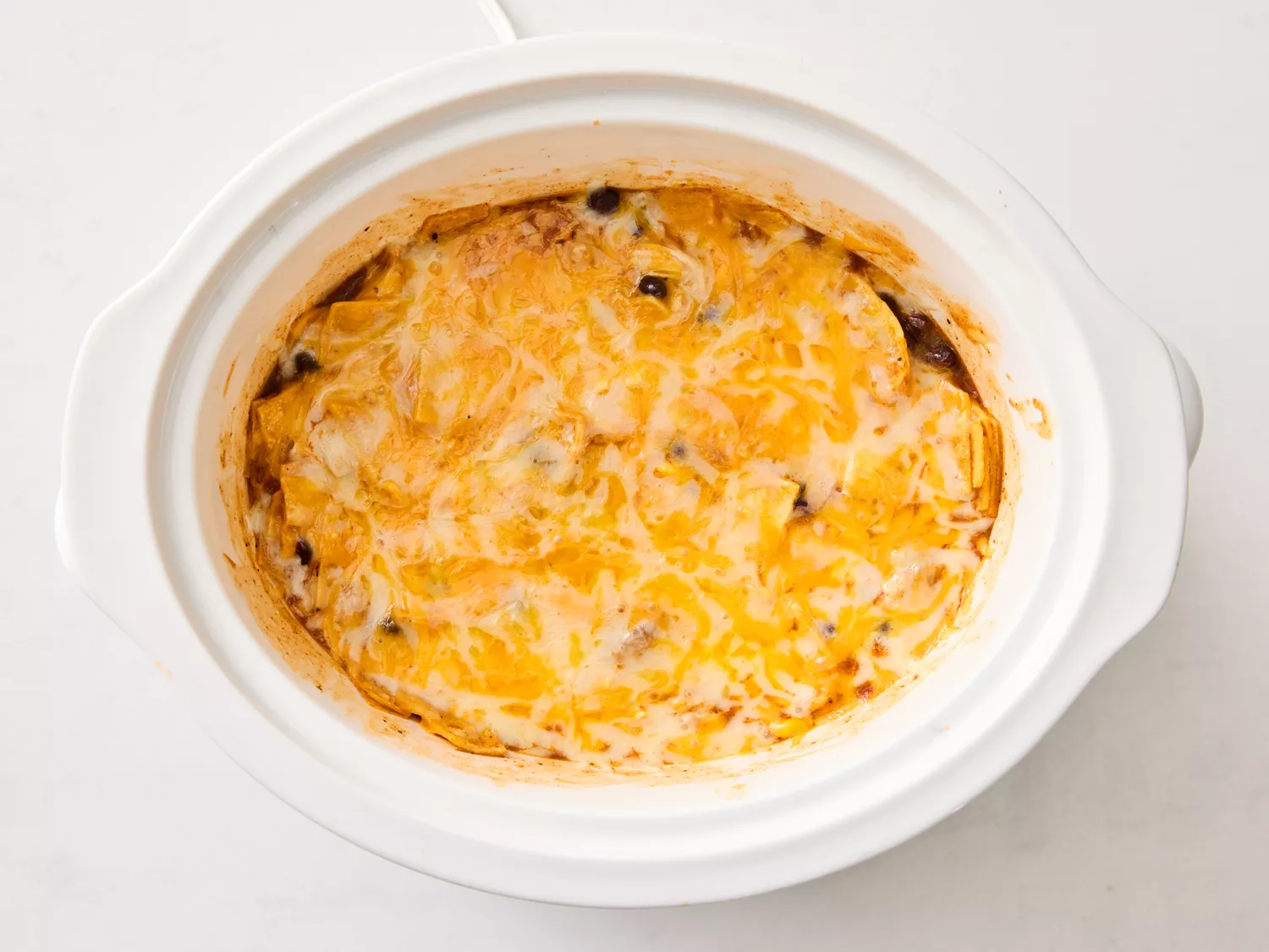 Melted cheese on the chicken enchilada casserole in the slow cooker
