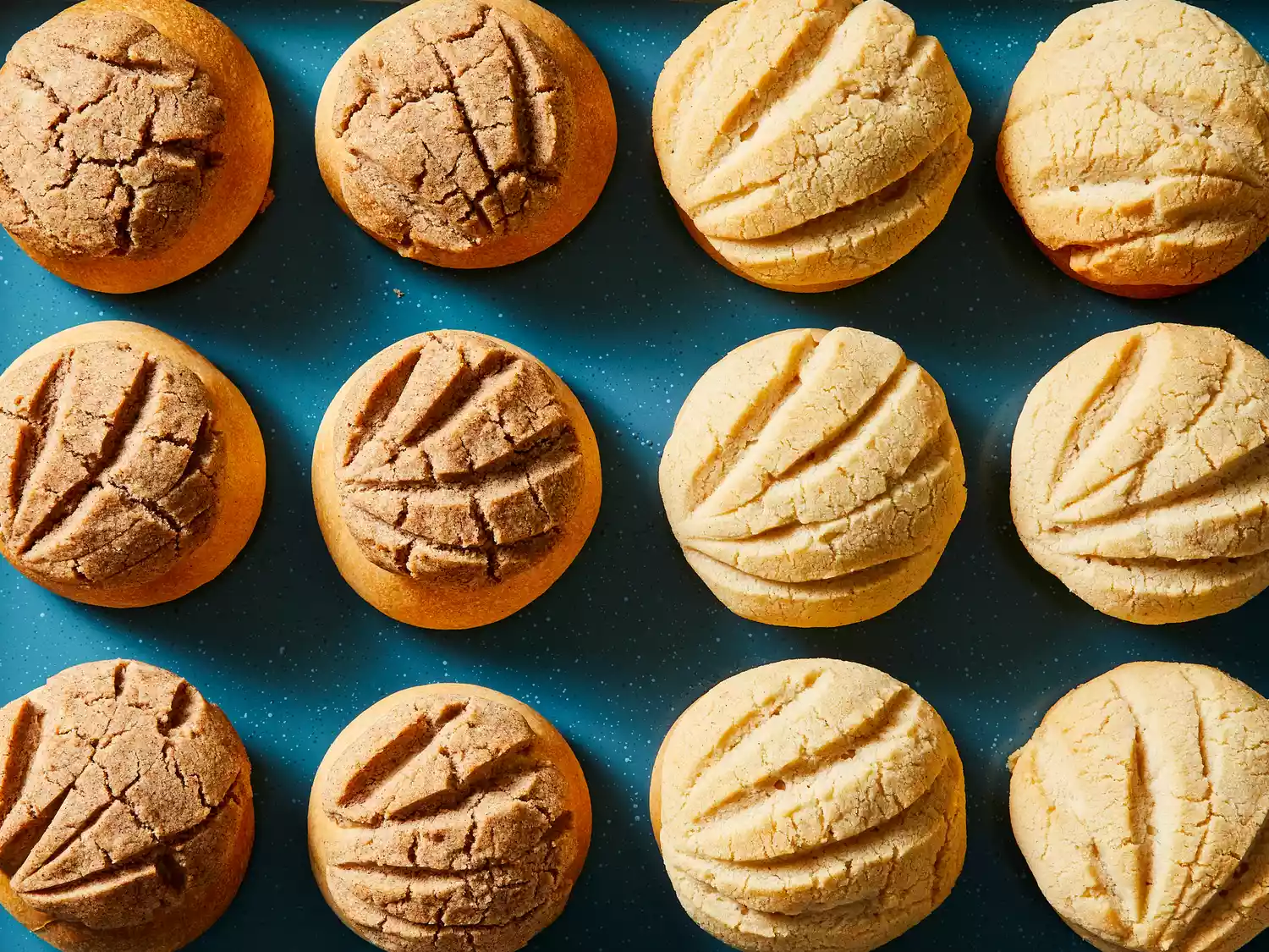 Looking down at a bunch of golden brown conchas on a tray.