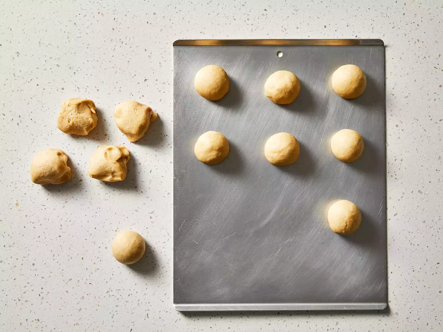 Dough shaped into balls and placed on a baking sheet.