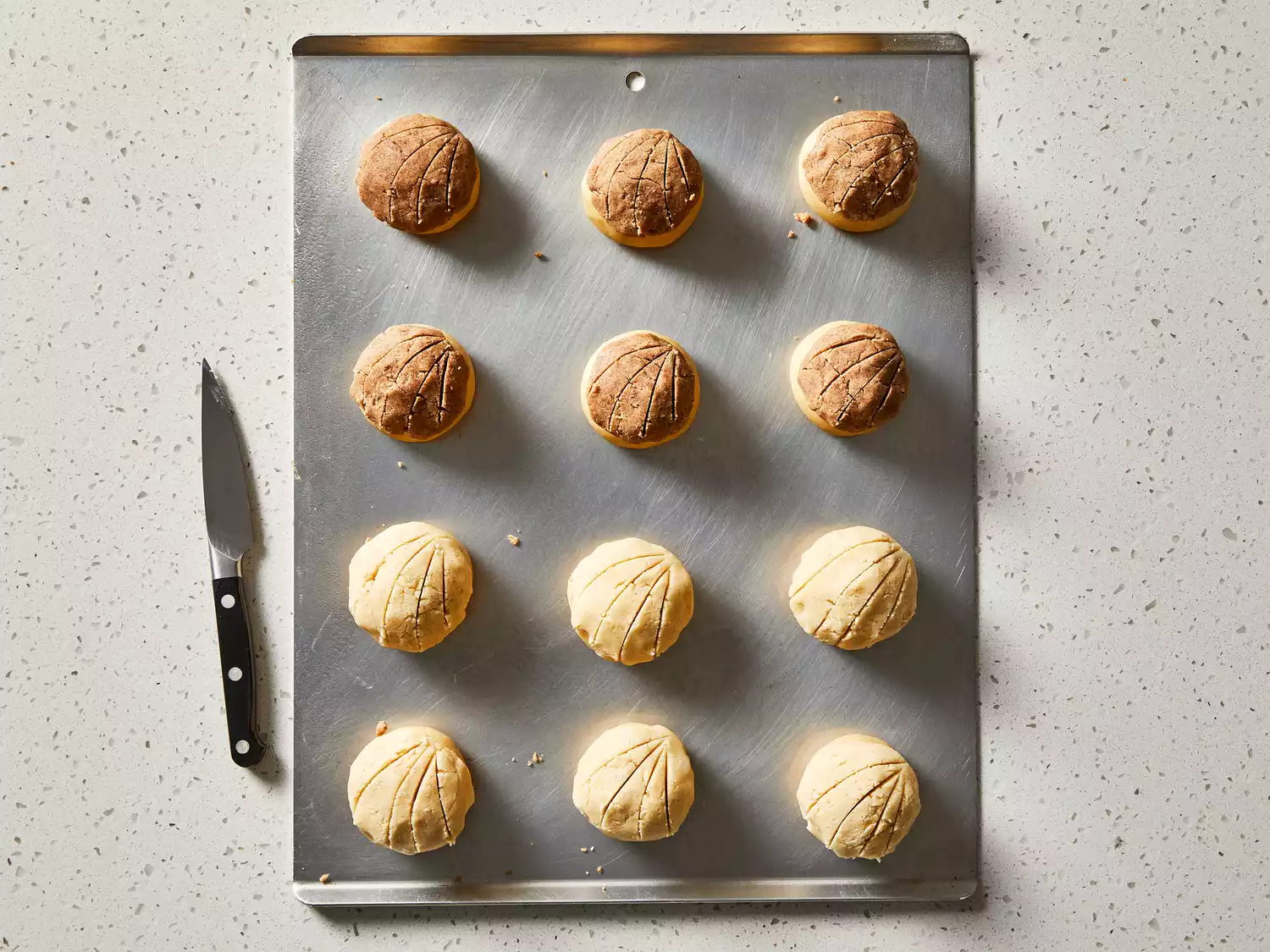 Dough topping placed on each ball and slightly patted down, then grooves cut into each.