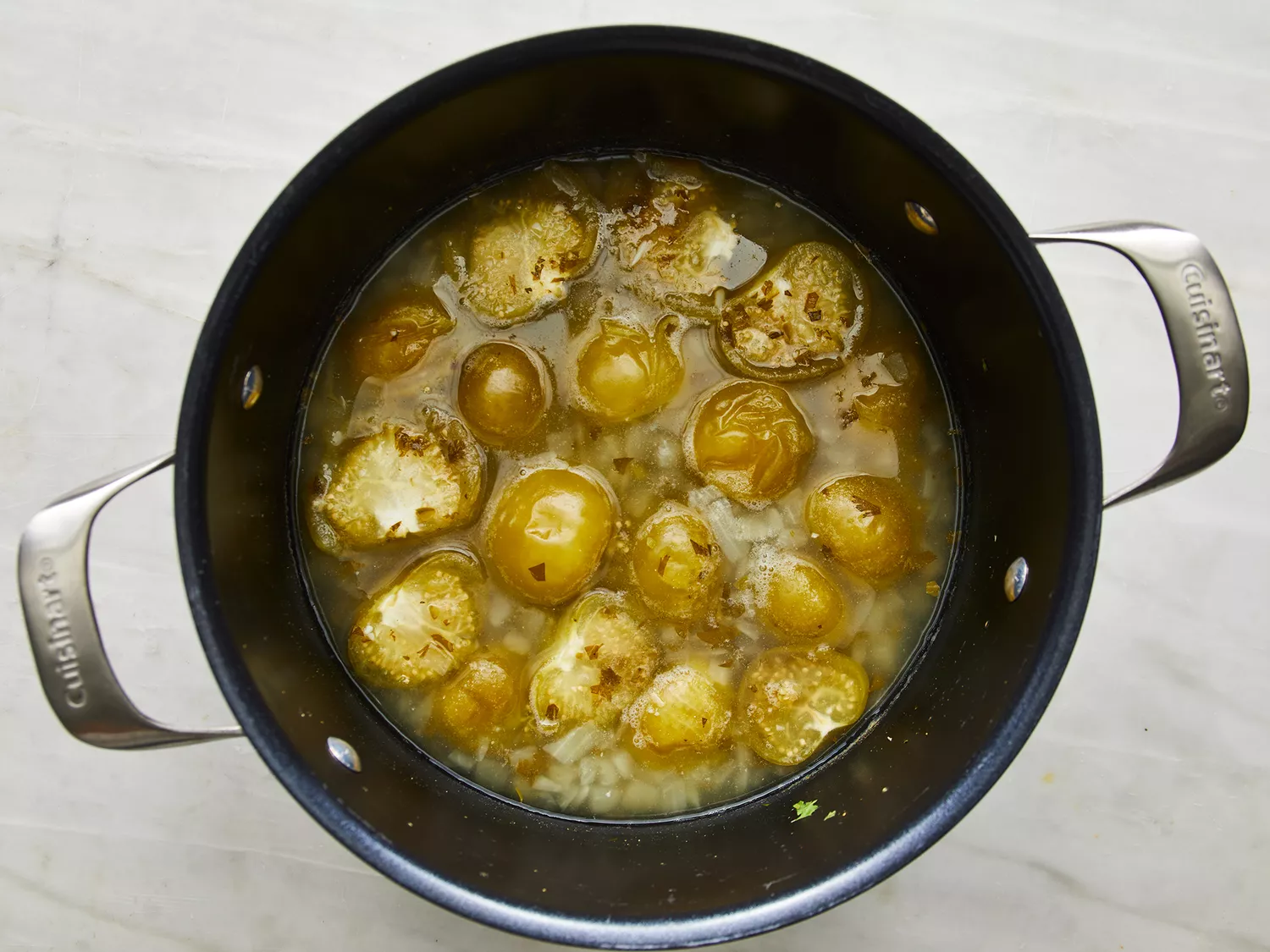 Tomatillos cooking in a pot for salsa verde, as seen from above