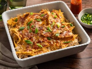 Baked nachos with melted cheese, shredded chicken, and green onions.