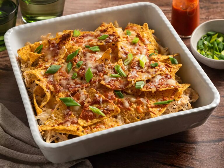 Baked nachos with melted cheese, shredded chicken, and green onions.