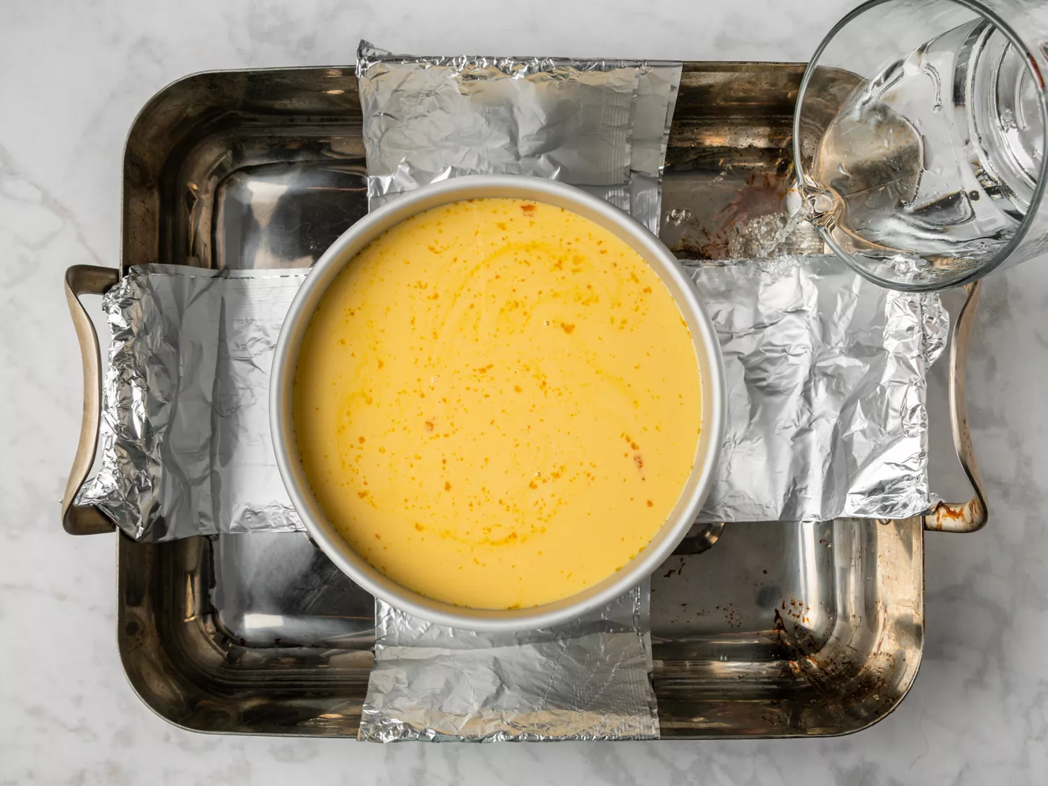 Water being poured into a tray for the flan’s water bath.
