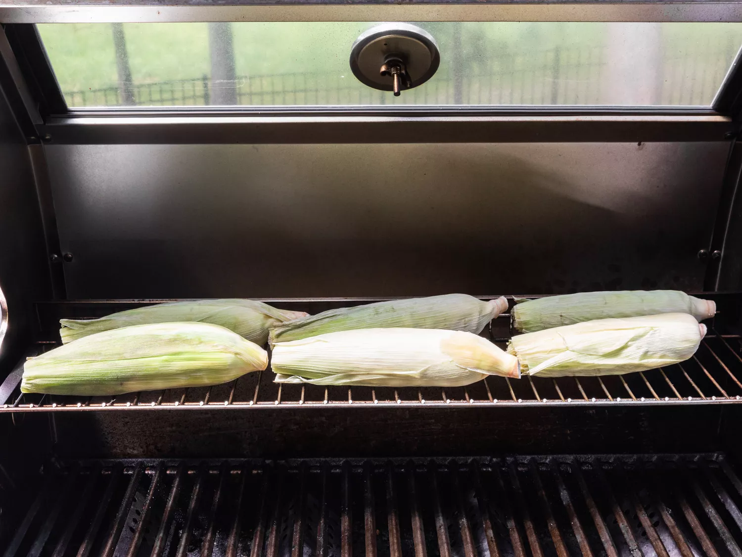 Ears of corn on a grill for barbecuing.